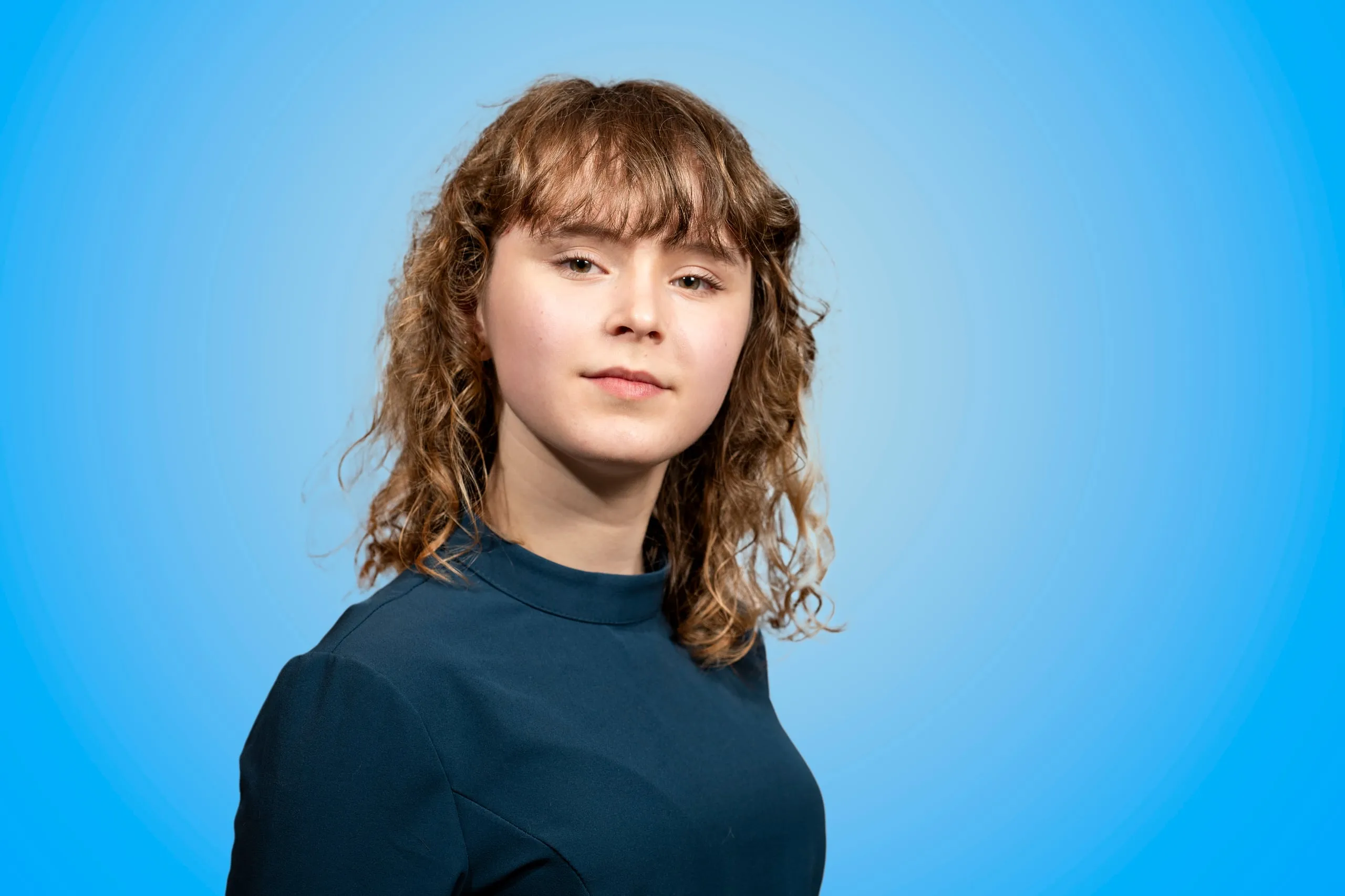 Hoofd-en-schouderportret van een jonge vrouw met krullend haar