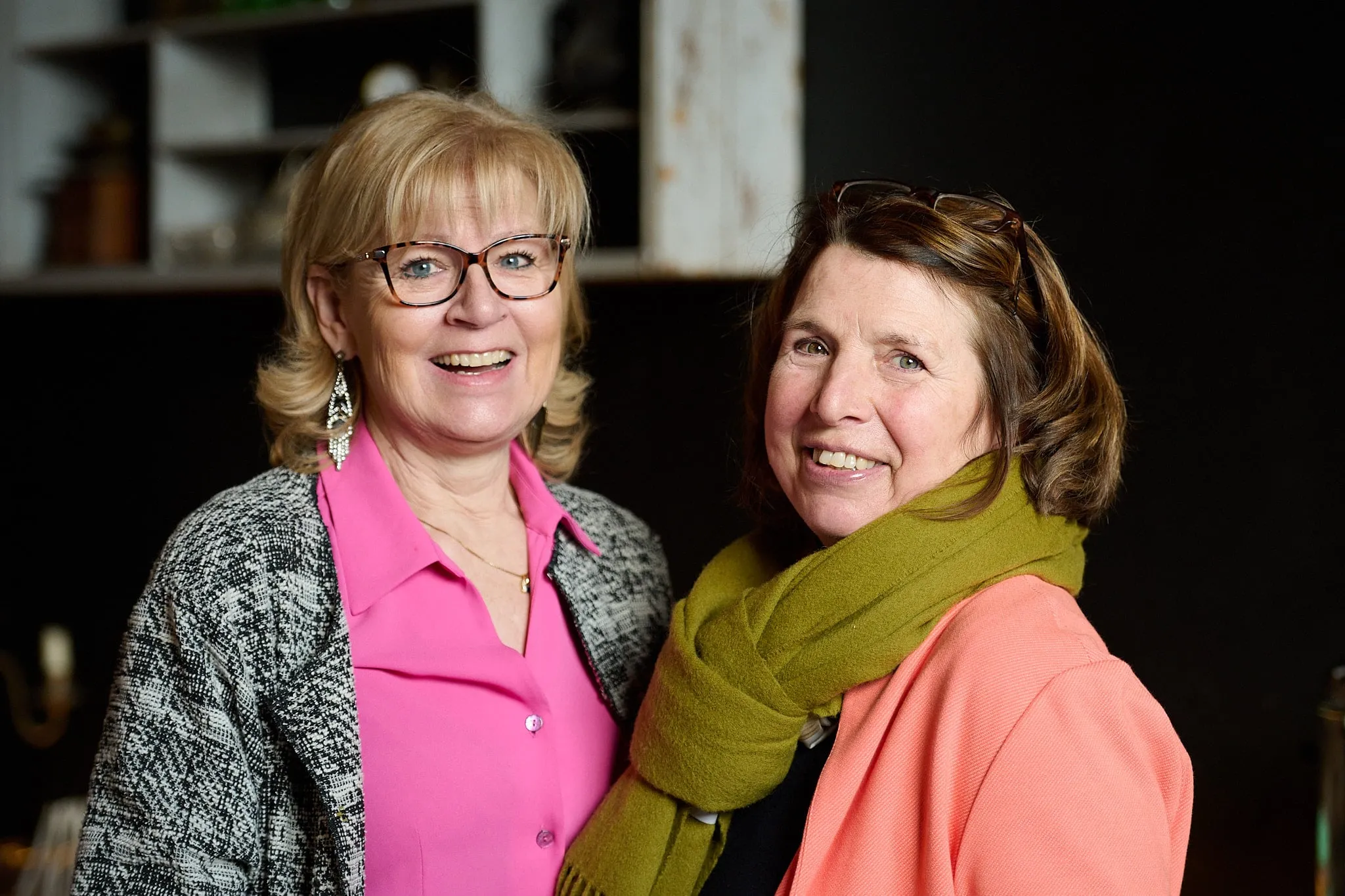 Twee lachende vrouwen poseren samen in het café