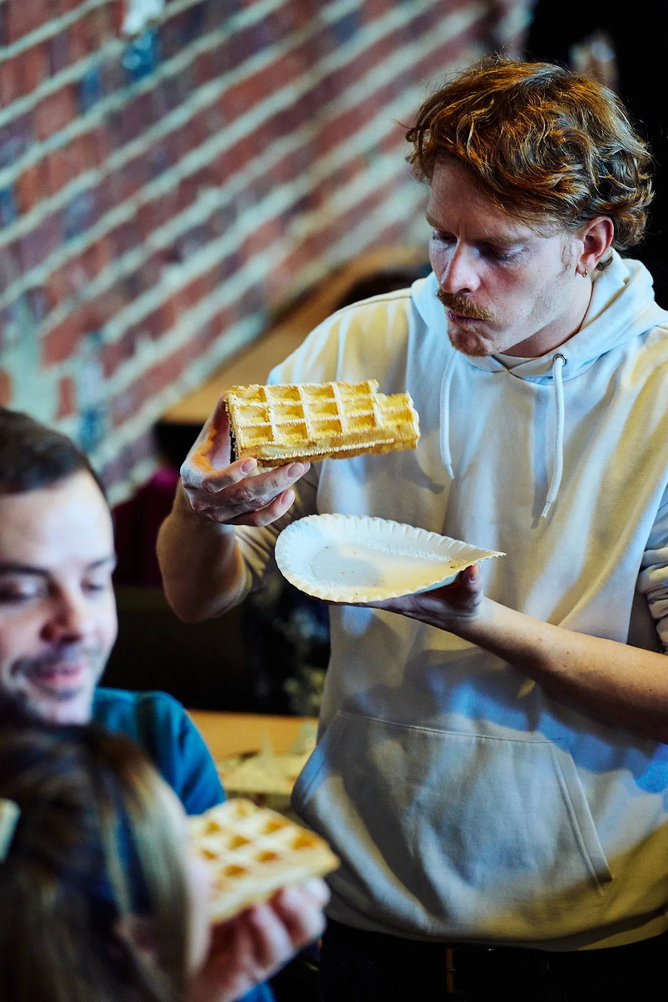 Jonge man bekijkt een wafel in zijn hand