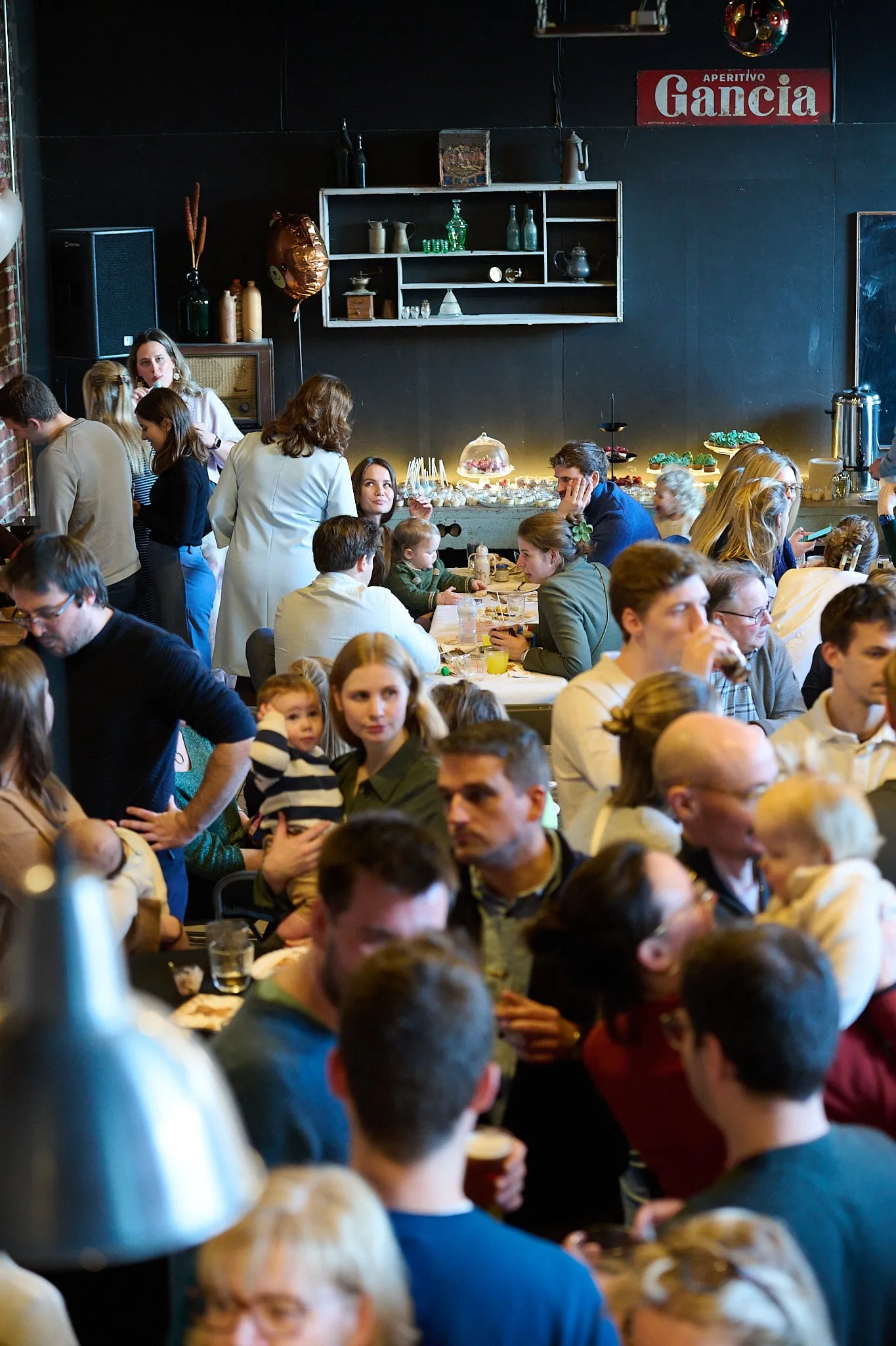 Drukke zaal vol gasten aan tafel, van bovenaf gezien