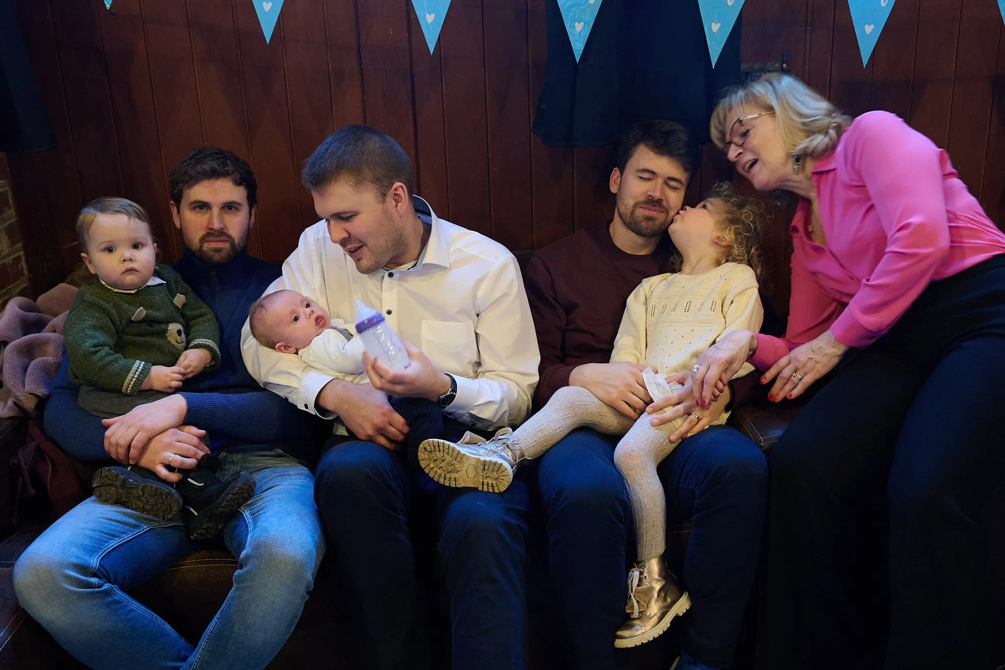 Familie zit samen op de bank met baby, peuter en kinderen