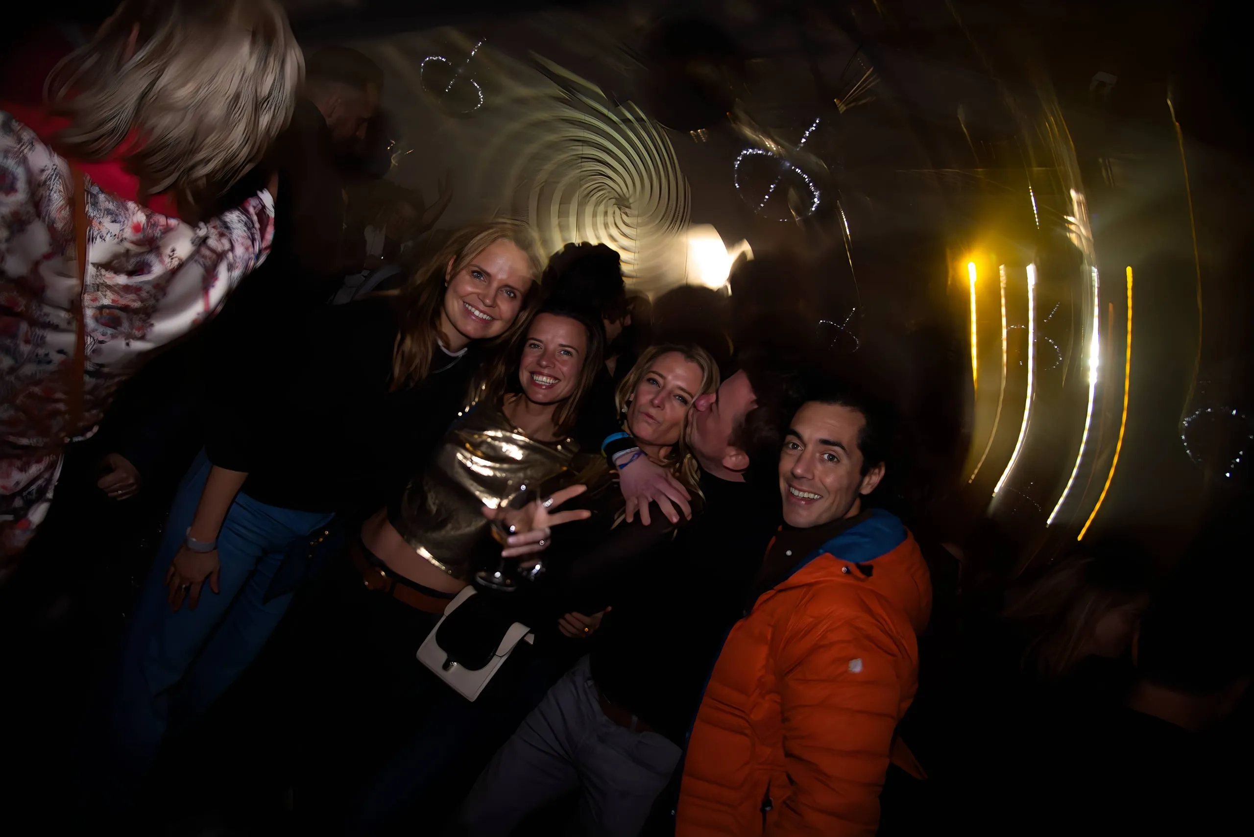 Groep vrienden poseert in het donker met lichtstrepen op de achtergrond