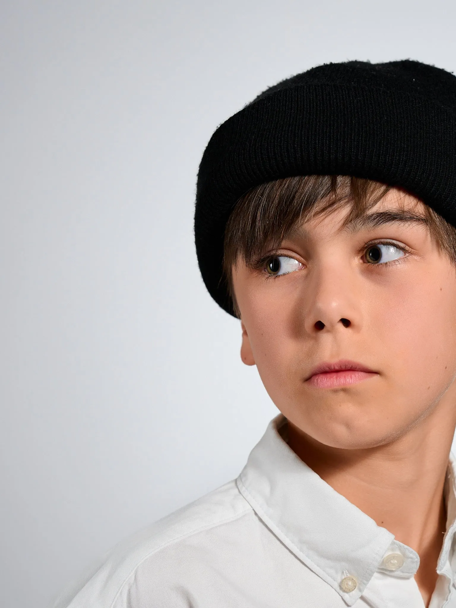 Portret van een jongen met zwarte muts die opzij kijkt