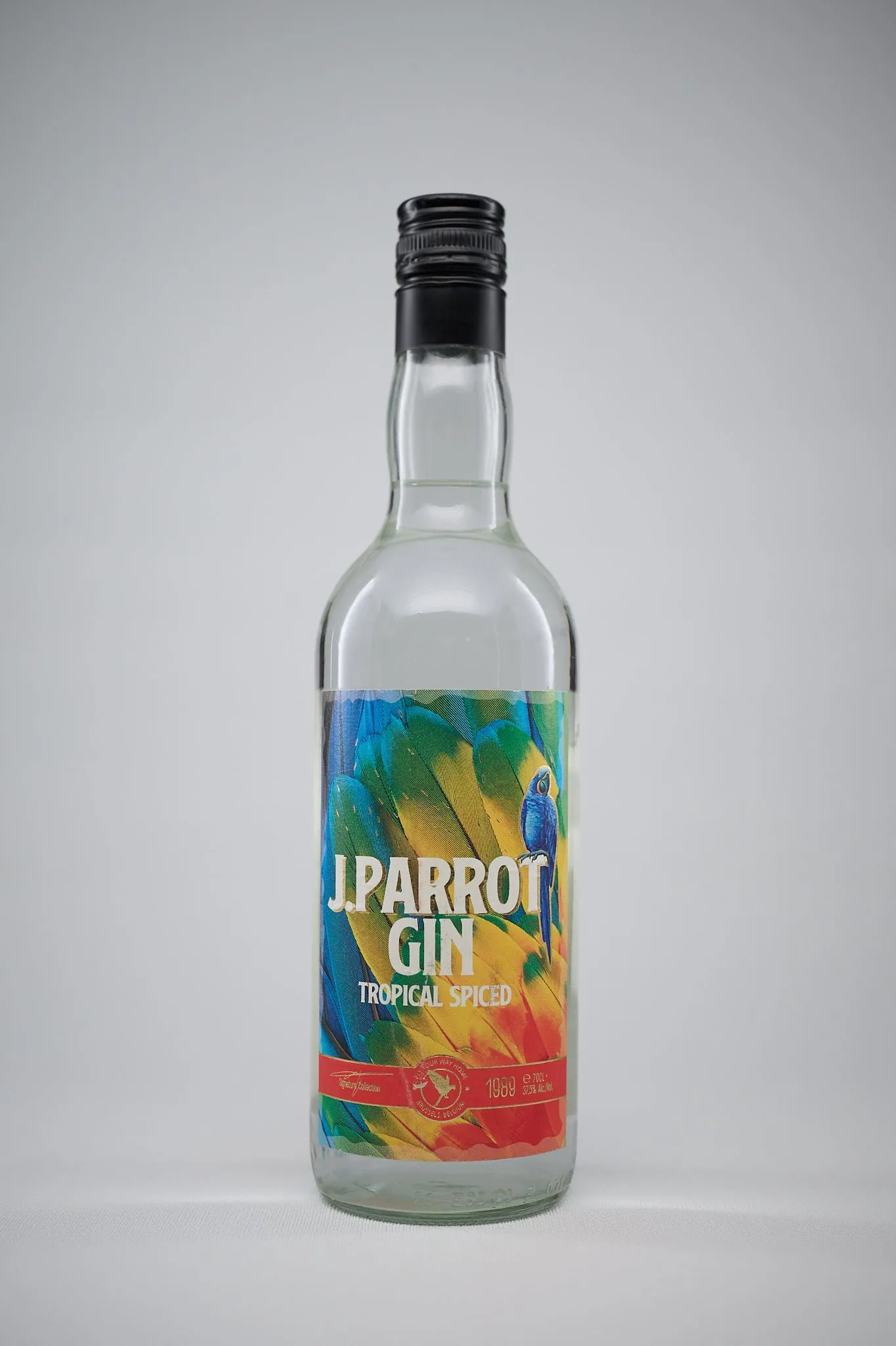 Fles J. Parrot Gin Tropical Spiced tegen een lichtgrijze achtergrond