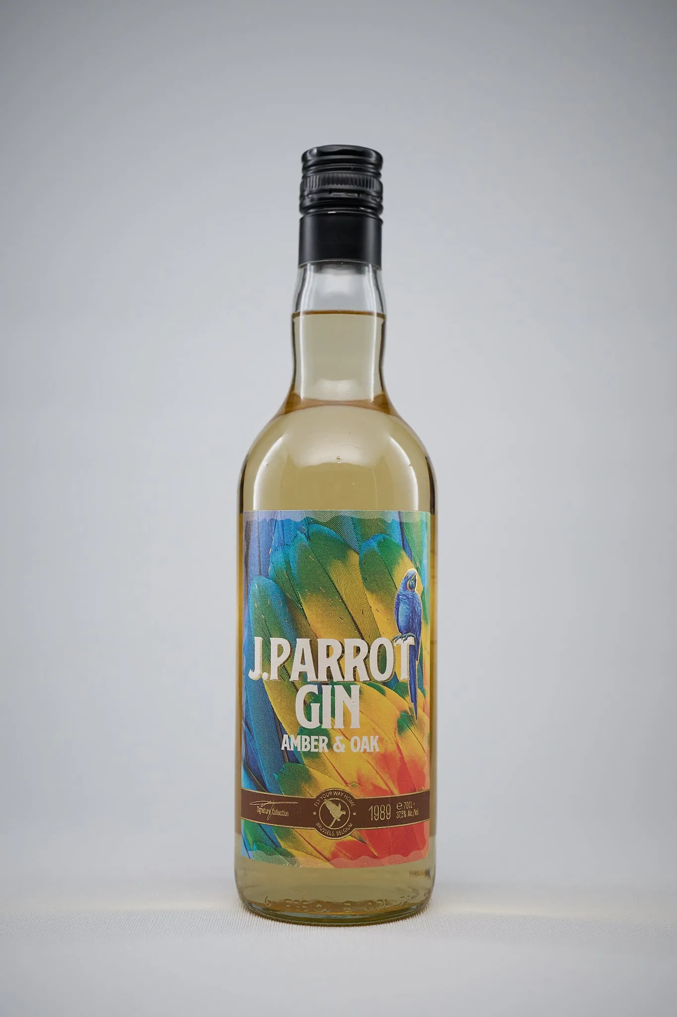 Fles J. Parrot Gin Amber & Oak tegen een lichtgrijze achtergrond